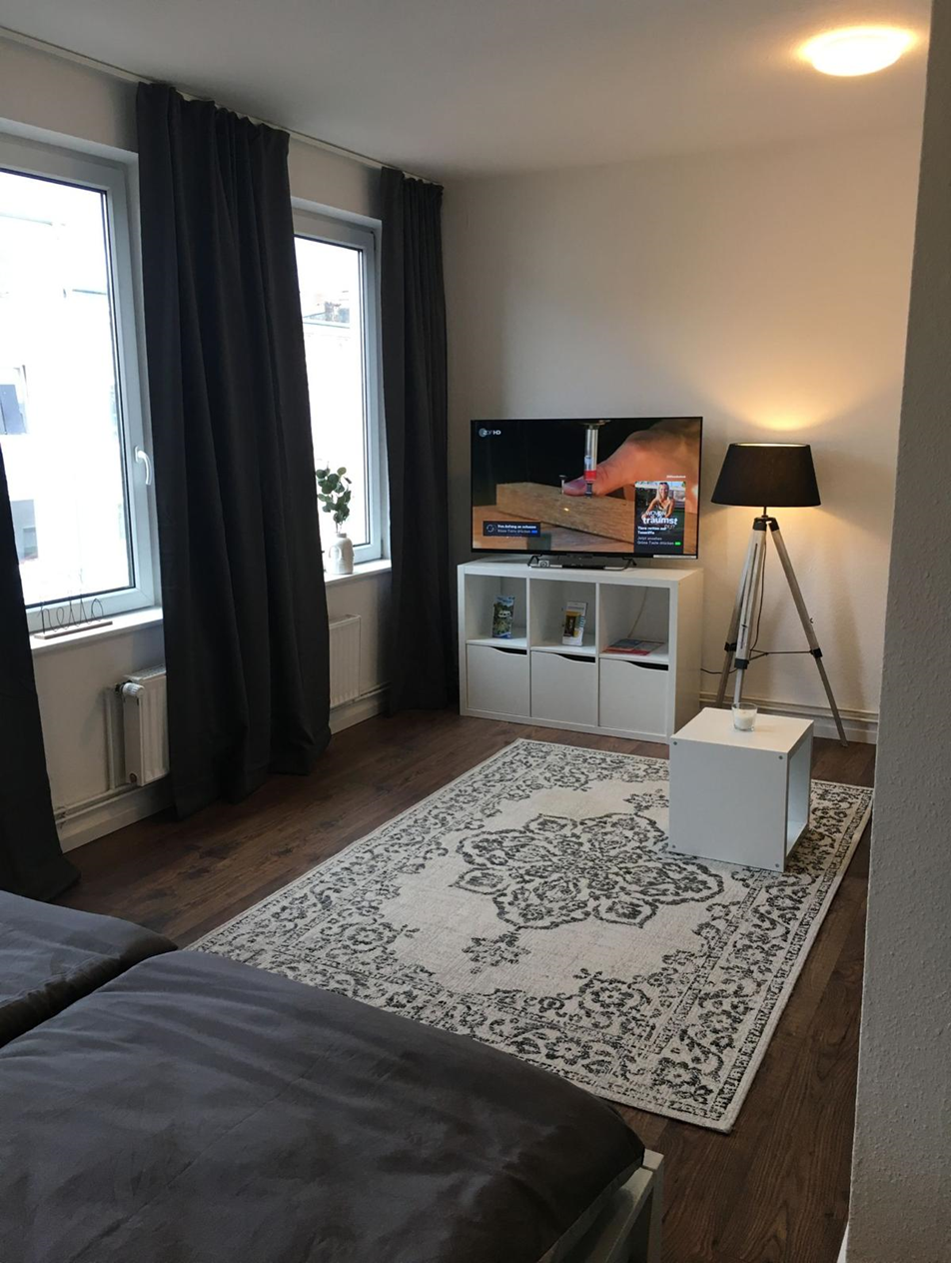 Gemütlicher Wohnbereich mit TV und Teppich
